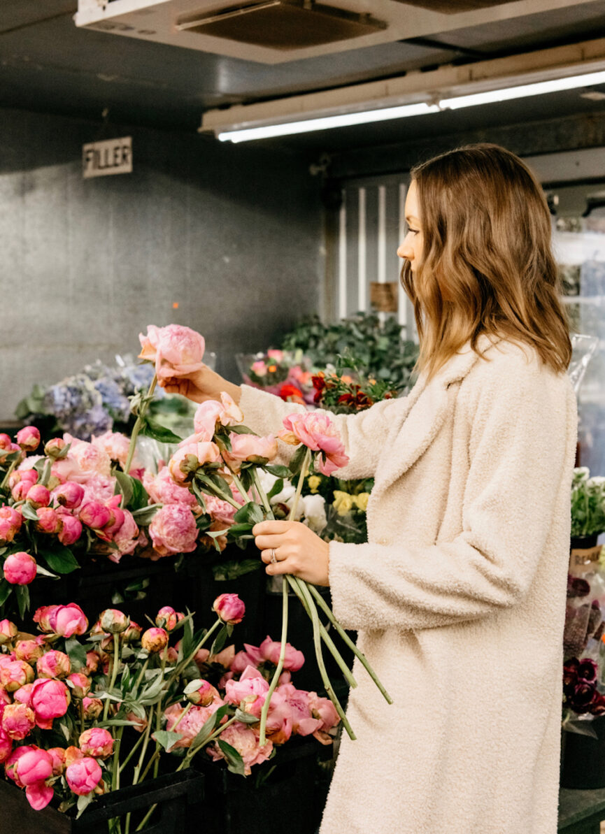 Woman buying flowers at market.
