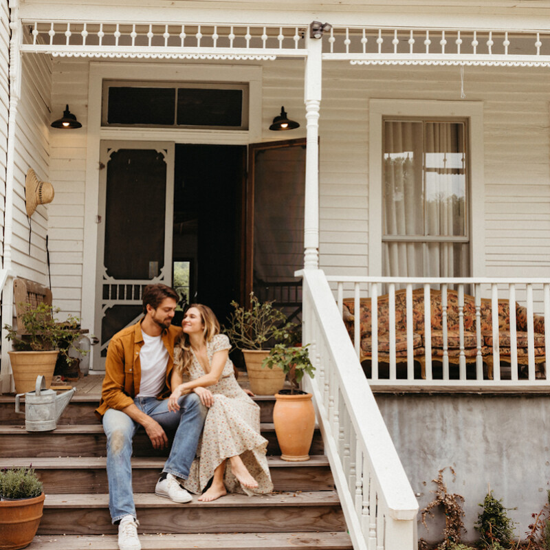 Couple embracing on porch.