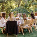 Women seated at outdoor table for Galentine's Day.